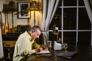 Man writing on a notebook in a fancy room - Wealth Creation Plan Image