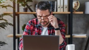 man worried looking at laptop - risk management test blog image