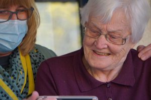 Old lady smiling looking at phone - Age Care Planning Image