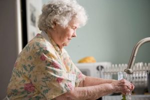 An Elderly Woman Washing Dishes - The Different Levels of Support When Going Into Aged Care - Wealth Connexion Blog Image