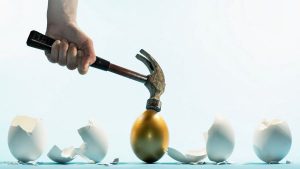 A person hammering a gold egg with egg shells on side - Wealth Connexion Blog Image