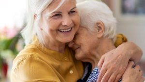 Two elder woman hugging - Wealth Connexion