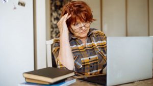 A woman looking at her laptop stressed - retirement wrongs - Wealth Connexion blog image