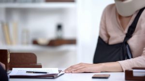 Person with neck brace and arm sling in an office - Wealth Connexion blog image