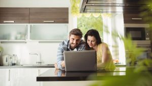 A couple looking through a laptop in a kitchen | Wealth Connexion blog image