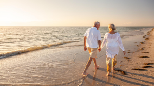 Elderly couple walking along the seashore | Wealth Connexion blog image