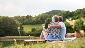 Couple enjoying outdoor while on a picnic and a glass of wine | Wealth Connexion blog image