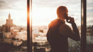 Person on a phone on a high rise building | Wealth Connexion blog image